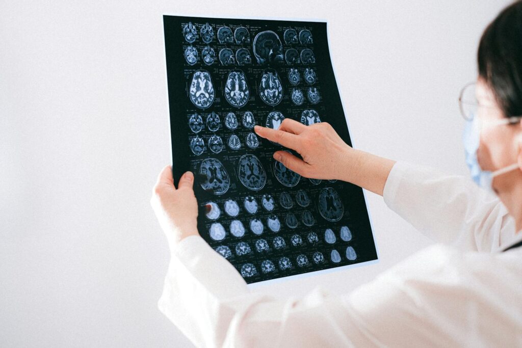 Doctor examines brain MRI scans closely for medical diagnosis in a hospital environment.