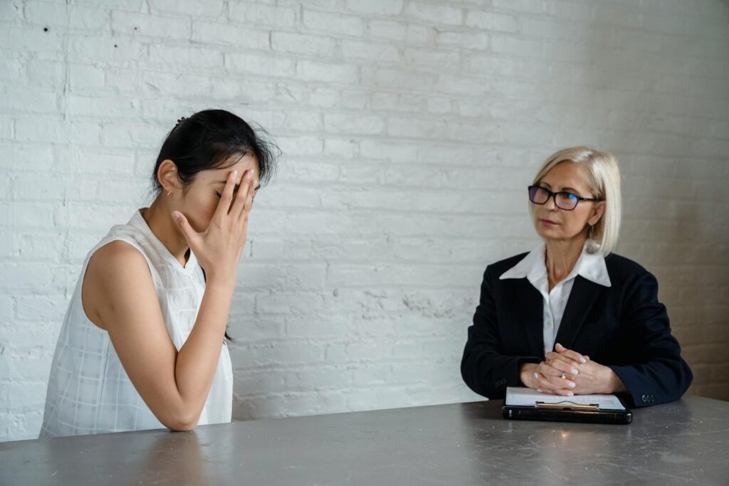 A therapist listens to a patient in an office during a counseling session.